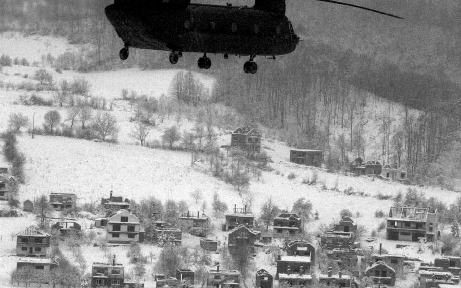 A Chinook of the 159th Aviation Regiment flies over a destroyed village in Bosnia early in the NATO-led Implementation Force mission Joint Endeavour, which began Dec. 20, 1995. The scars of war were a familiar sight for IFOR soldiers in Bosnia-Herzegovina.