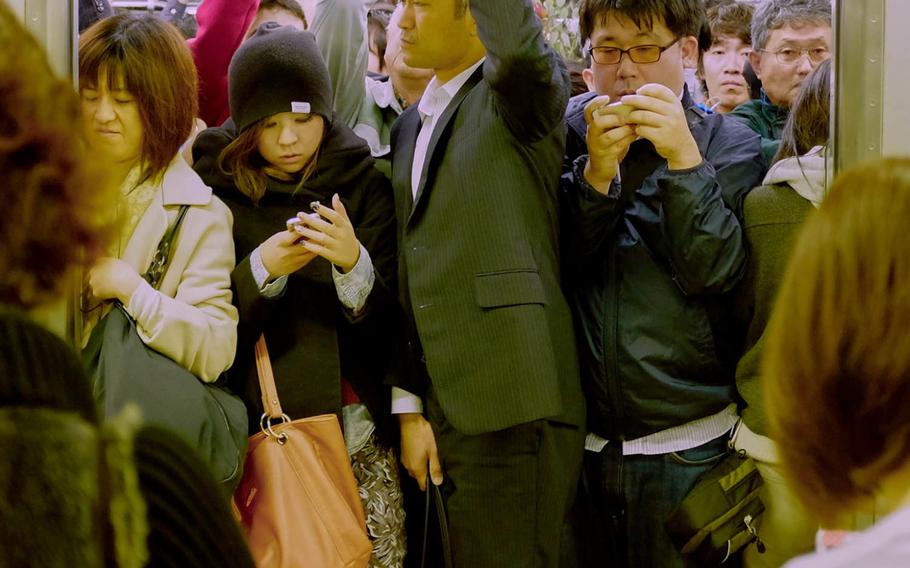 Commuters pack into a train car at Shibuya Station in Tokyo,  Nov. 28, 2014. Complimentary Wi-Fi on the city's Asakusa subway line becomes available for all passengers starting Feb. 5, 2016. The line will be the first of the Tokyo Metropolitan Bureau of Transportation's subways to offer the free Internet. The bureau expects the service to expand to all lines by March 2020.