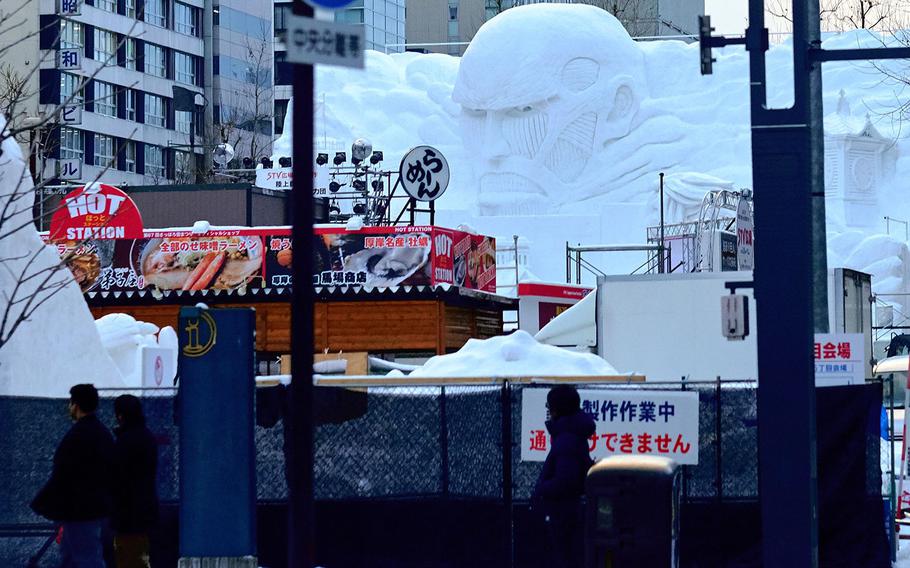 Parts of the snow sculpture  depicting the hit manga Attack on Titan stares out over the team's barricade Feb. 3, 2016 in Sapporo, Japan's Odori Park. The Sapporo Snow Festival is scheduled to start Friday, Feb. 5 with the final displays being taken down by February 18.