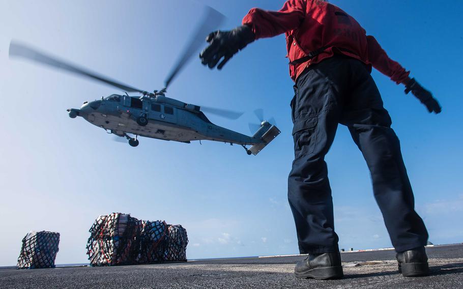 Airman Kersan Sorendo, an aviation ordnanceman, directs an MH-60S Sea Hawk assigned to Helicopter Sea Combat Squadron 14 during an replenishment-at-sea with USNS Henry J. Kaiser on USS John C. Stennis' flight deck Feb. 1, 2016.