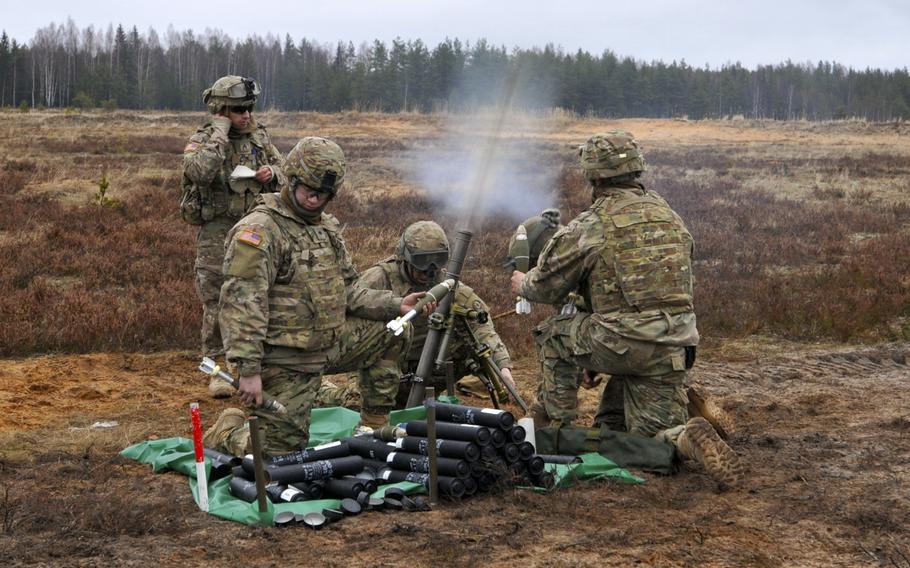 Soldiers of Mortar Platoon, Headquarters and Headquarters Troop, 3rd Squadron, 2nd Cavalry Regiment react to a 60mm high explosive mortar round being fired during mortar training and evaluation at Adazi Training Area, Latvia, on Feb. 3, 2016.