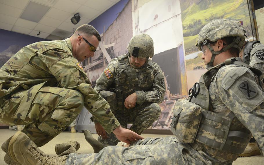 Sgt. 1st Class James Austin, an instructor with the Medical Battalion Training Site, 166th Regiment, Regional Training Institute, Pennsylvania Army National Guard, assists Sgt. Todd Turner, 155th Chemical Battalion, Ohio National Guard, with bandaging a wound on role-playing patient Spc. Shane Hines, 118th Infantry Regiment, South Carolina National Guard during training at Fort Indiantown Gap, Pa., Feb. 3, 2016.