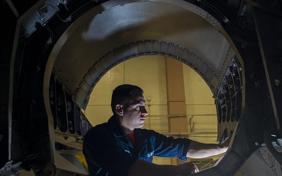 U.S. Air Force Airman 1st Class Jorge Pauker, 18th Equipment Maintenance Squadron inspection section team member, inspects the back of an F-15 Eagle after the engine was pulled out, Jan. 28, 2016, at Kadena Air Base, Japan. The aircraft is in phase, which is where it is pulled into a hangar and pulled apart to inspect every function.