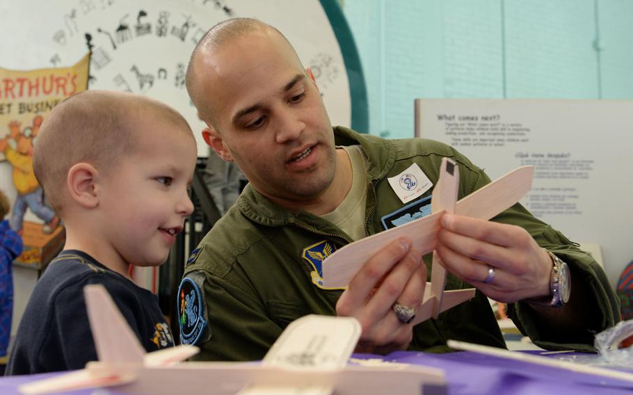 Capt. Hansel Rabbell, 28th Operations Support Squadron chief of wing scheduling, explains the a toy glider to Tonda Winifred-Morris during the 2016 Aviation Day at the Discovery Center in Pierre, S.D., Jan. 27, 2016. This was the third annual event of its kind, and is one of several youth events organized by the Elks Lodge.