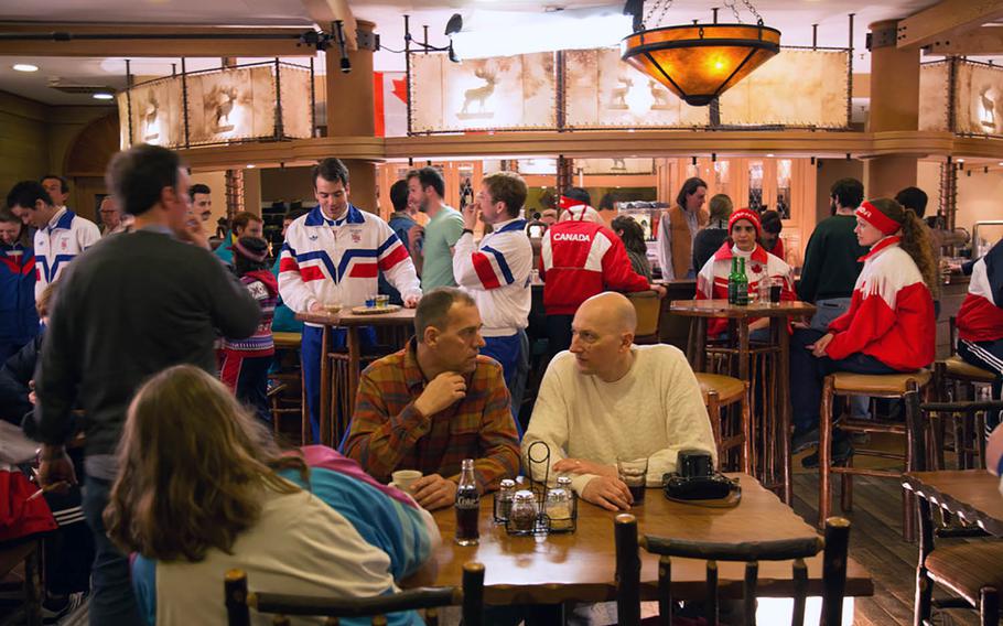 Extras portray international teams relaxing at the 1988 Calgary Olympic headquarters in the new movie "Eddie the Eagle." The setting is a bar called Zuggy's Base Camp at Edelweiss Lodge and Resort, an Armed Forces recreation center located in the Bavarian Alps. Filming took place there in March 2015.