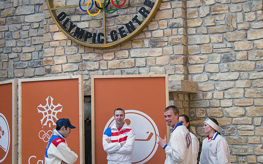 Edelweiss Lodge and Resort employees in Garmisch-Partenkirchen, Germany, portray skiers at the 1988 Olympic headquarters in Calgary, Alberta, Canada. Here, they gather under an Olympic emblem added as a prop above the resort's main lobby fireplace.