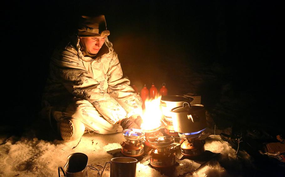U.S. Marine Cpl. Charles Roy III, an optics technician assigned to the Combined Arms Company out of Bulgaria, uses small burners to melt snow into water as his unit sets up camp for the night, on Feb. 22, 2016.