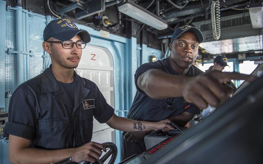 Seaman Michaelangelo Alvarado, from El Centro, Calif., left, and Seaman Demarcus Lawrence, from Port Arthur, Texas, assigned to the Ticonderoga-class guided-missile cruiser USS Antietam, man the helm from the ship?s bridge on Feb. 19, 2016.