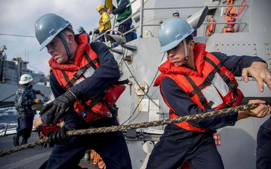 Sailors aboard the guided-missile destroyer USS Chung-Hoon haul in handling line during a replenishment-at-sea with the fast combat support ship USNS Rainier on Feb. 22, 2016.