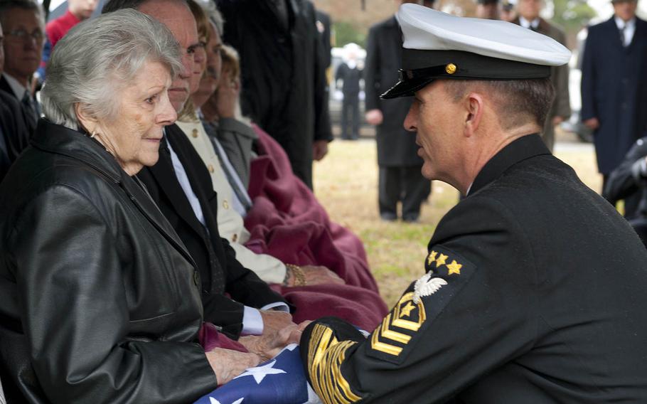 Master Chief Petty Officer of the Navy Mike Stevens presents the national ensign to Fran Walker during the burial service for MCPON Robert J. Walker on Feb. 23, 2016.