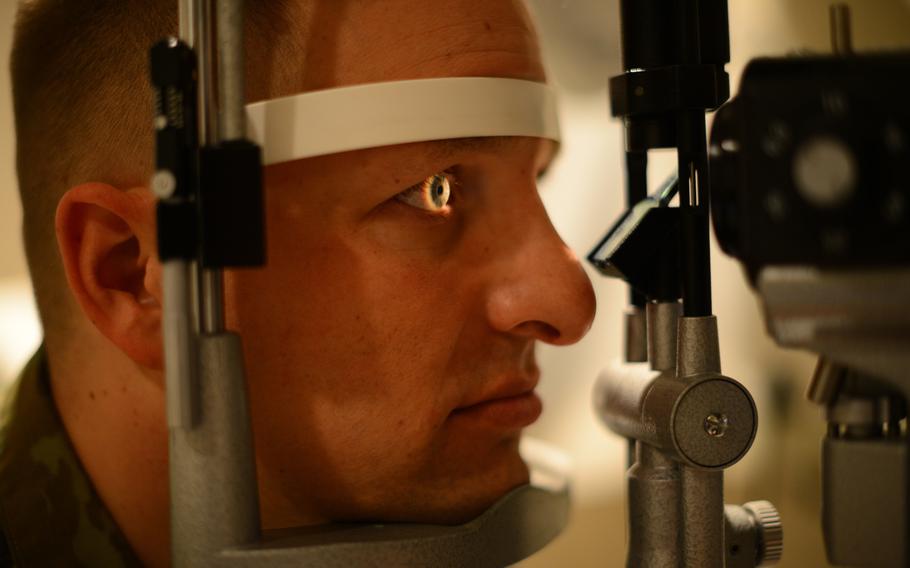 Lt. Col. David Nowicki, 451st Expeditionary Sustainment Command inspector general, looks into a slit-lamp vision during an eye exam, Feb. 24, 2016, at McConnell Air Force Base, Kan.