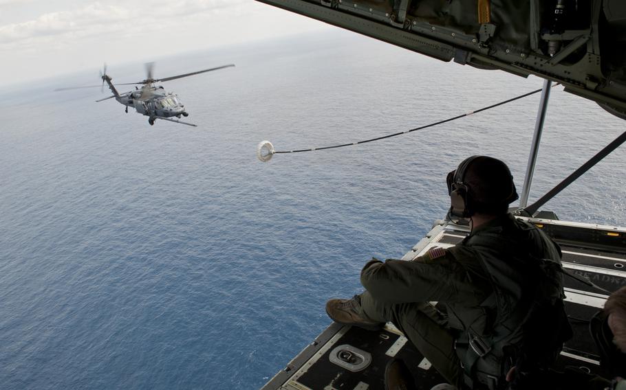 Senior Airman Zach Harmon, 17th Special Operations Squadron MC-130J Commando II loadmaster, observes a 33rd Rescue Squadron HH-60G Pave Hawk helicopter air-to-air refueling during a training exercise Feb. 17, 2016, off the coast of Okinawa, Japan.