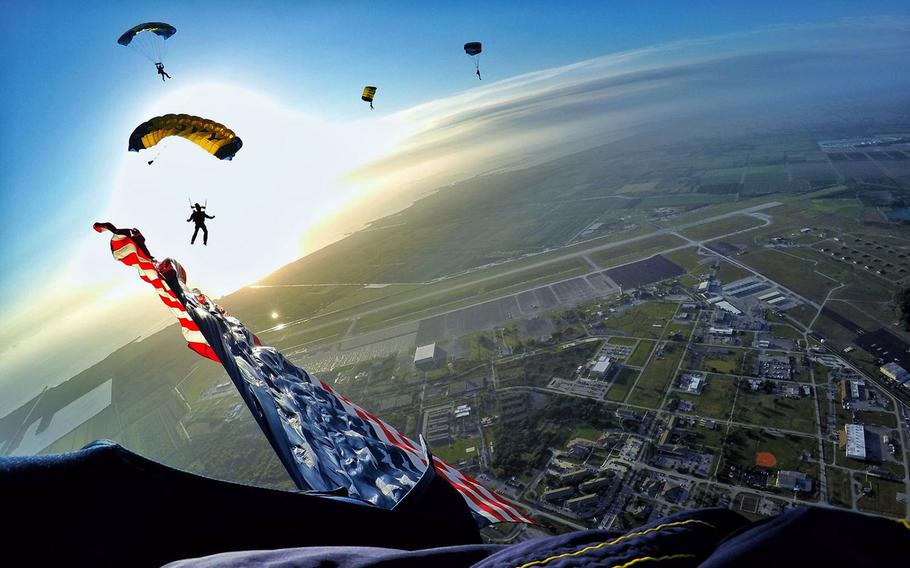 Petty Officer1st Class Trevor Thompson, member of the U.S. Navy Parachute Team ''The Leap Frogs,'' flies the American Flag during a sunrise training demonstration at Homestead Air Reserve Base, Fla., on Feb. 25, 2016.