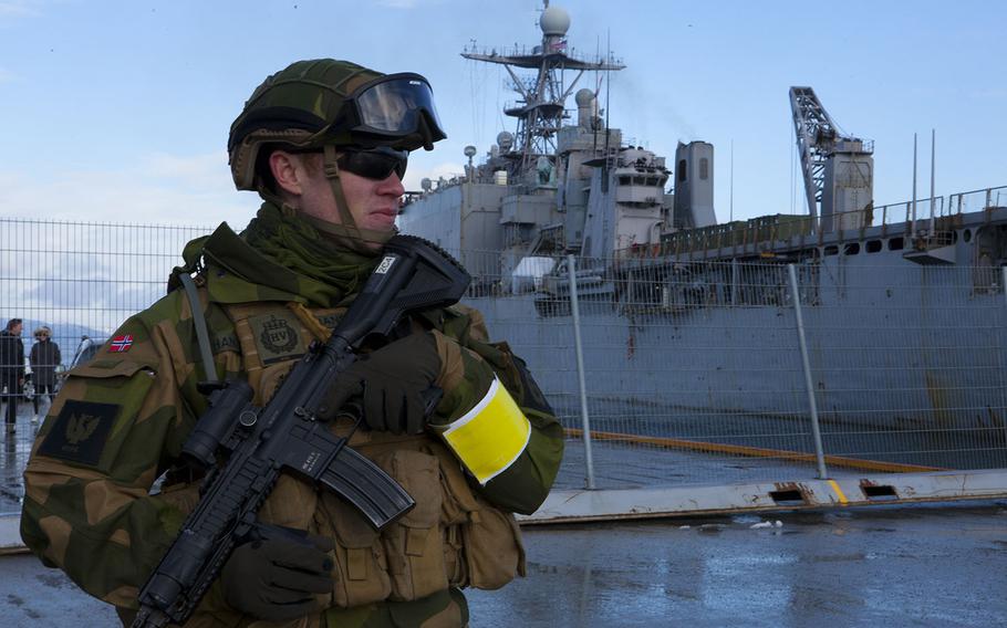 A Norwegian soldier provides security as the USS Fort McHenry is towed to a pier as a part of Cold Response 16 on Sunday, Feb. 28, 2016, at Trondheim, Norway.
