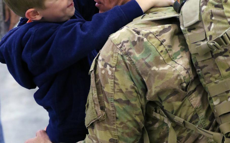 A boy embraces his father during a welcome home at Green Ramp on Fort Bragg, N.C., March 9, 2016. The paratroopers assigned to Headquarters and Headquarters Battalion, 82nd Airborne Division, returned home from a nine-month deployment in support of Combined Joint Task Force- Operation Inherent Resolve.