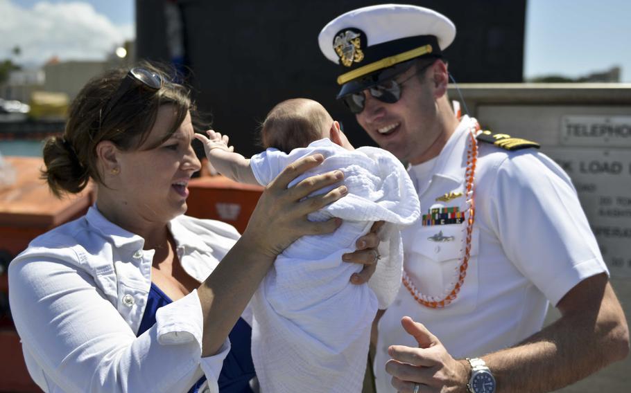 Lt. Cmdr. Sean Gray, executive officer of the USS Texas, see his 7-week-old daughter, Vivian, for the first time. Vivian and her mother, Jennifer, were are Joint Base Pearl Harbor, Hawaii, on March 9, 2016, for the return of the submarine following its Western Pacific deployment.