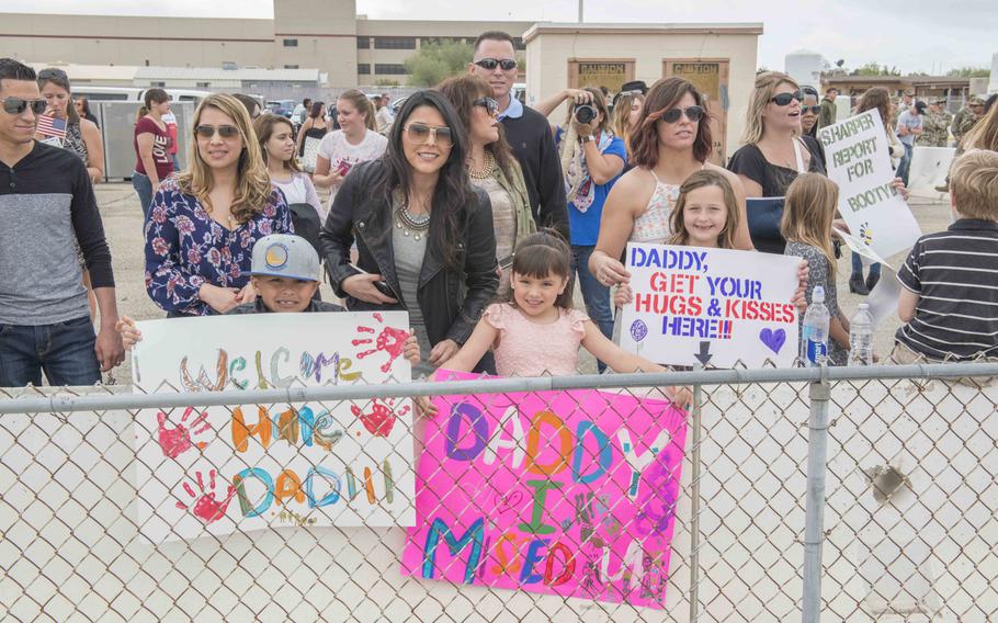 Family members hold up signs March 13, 2016, at Naval Base Ventura County, Calif., where they welcomed home family members from Naval Mobile Construction Battalion 3.The Seabees were coming back from a six-month deployment to the U.S. Pacific Command area of operations.