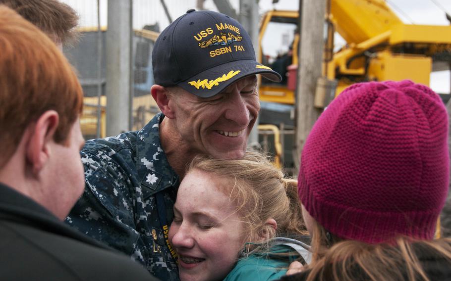 Cmdr. Kelly Laing, commanding officer of the Blue crew of the USS Maine, is welcomed home to Naval Base Kitsap-Bangor, Wash., by his family following a routine strategic deterrent patrol.