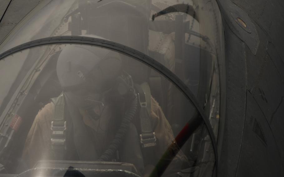 An F-15 combat systems officer looks over at the boom, a long arm that connects the fighter with a KC-135 Stratotanker during a midair refueling operation on March 24, 2016.