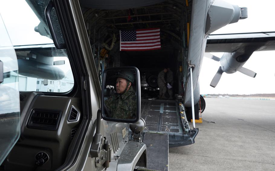 A Japan Ground Self-Defense Force soldier prepares to drive a military utility vehicle onto a U.S. Air Force C-130 Hercules from Yokota Air Base, Japan Tuesday, April 19, 2016 in Chitose, Japan.