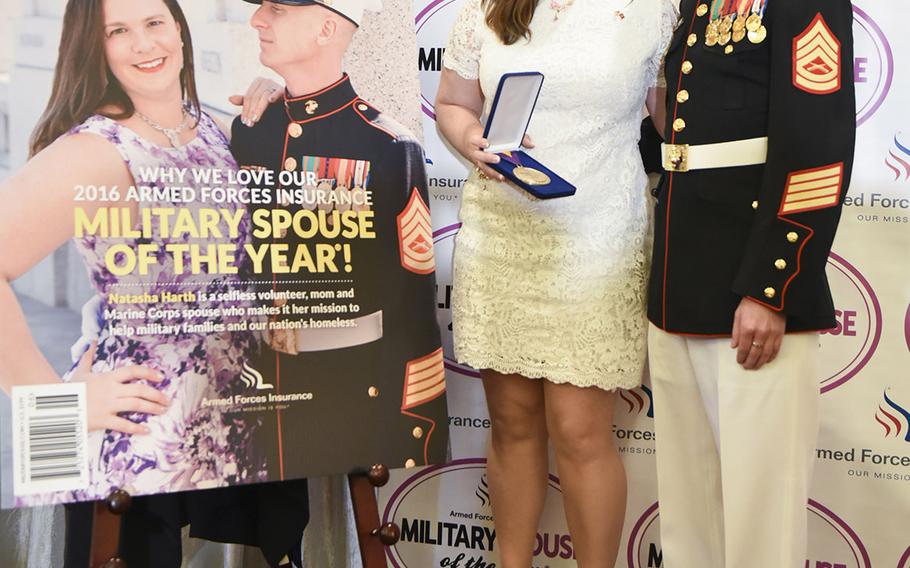 Gunnery Sgt. Patrick Harth and his wife, Natasha Harth pose for a photo next to the June cover of the Military Spouse magazine after Natasha was named The 2016 Armed Forces Insurance Military Spouse of the Year at an awards luncheon Thursday, May 5, 2016, at Fort Myer, Va.