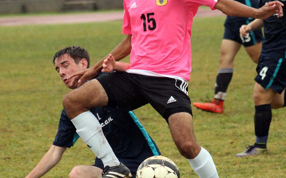 Kadena's Seith Garcia tries to elude the tackle of Seoul American's Brad Hilton during Tuesday's round-robin match in the Far East Division I Boys Soccer Tournament, won by the Panthers 2-0 over the defending champion Falcons.