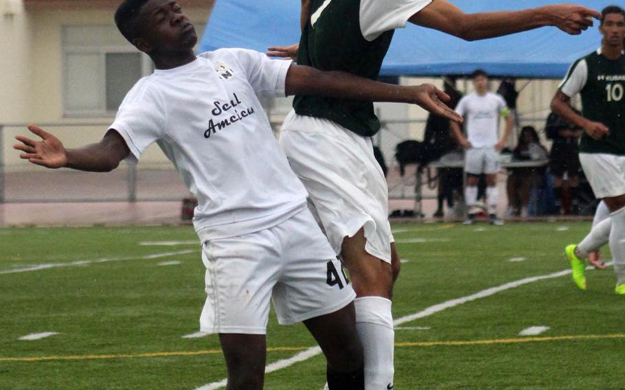 Kubasaki's Imani Washington goes up to head the ball against Seoul American's Kevin McGuire during Wednesday's playoff match in the Far East Division I Boys Soccer Tournament. The Dragons won 4-1, avenging last year's championship loss to the same Falcons on the same field.