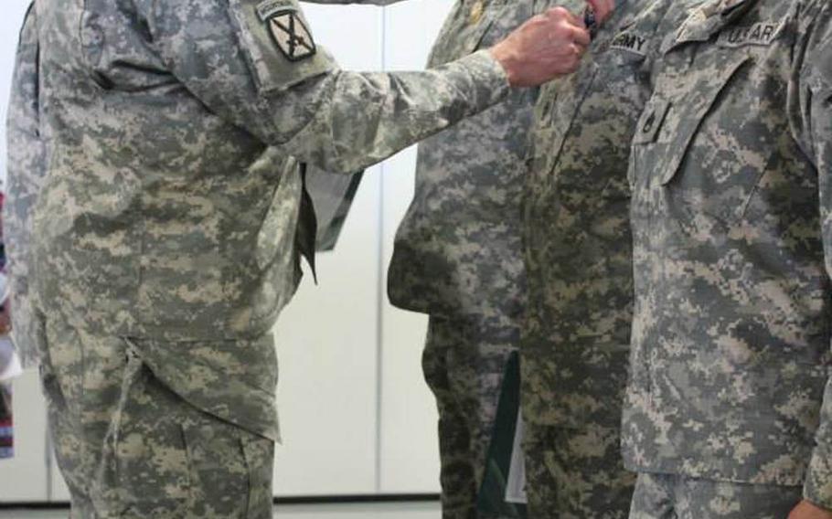 Brigadier Gen. Michael L. Howard, 10th Mountain Division, pins the Air Medal with "V" device for valor on Chief Warrant Officer 2 Melinda Walden, an HH-60 medical evacuation pilot, on May 7, 2014, at Fort Drum, N.Y. 