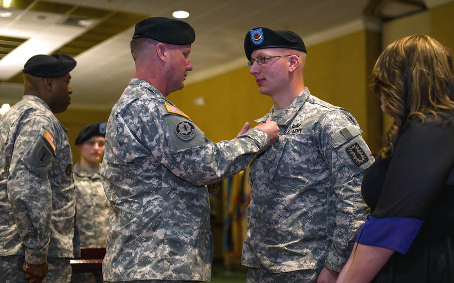 Spc. Nathan Currie, an explosive ordnance disposal specialist, receives the Soldier's Medal on Feb. 26, 2015, from Brig. Gen. James Blackburn.