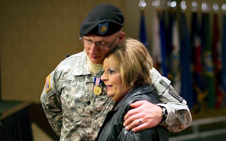 Army Spc. Nathan Currie shares a moment with Lora Chancey after receiving the Soldier's Medal on Feb. 26, 2015, for pulling Chancey out of a submerged vehicle in Holbrook Pond on the Fort Stewart base in Georgia.