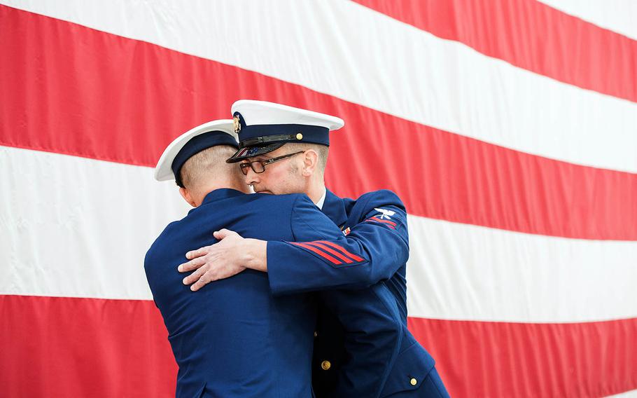 Petty Officer 3rd Class Evan Staph, left, and Petty Officer 2nd Class Derrick P. Suba hug at Coast Guard Air Station Cape Cod after receiving two of military aviation's most prestigious awards on Jan. 22, 2016. The Distinguished Flying Cross was presented to Staph and the Air Medal was presented to Suba for their heroic actions in February 2015 during a lifesaving rescue mission south of Nantucket.