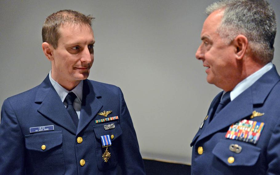 Lt. John Hess, left, speaks with Capt. Mark Morin, commanding officer of Air Station Kodiak, Alaska, about the mission that earned him the Distinguished Flying Cross on Feb. 5, 2016.