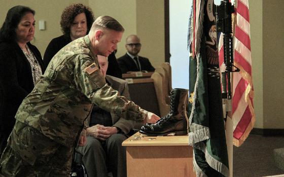 Maj. Gen. Bret Daugherty places a challenge coin at the boots of Sgt. 1st Class Matthew McClintock during a memorial at Joint Base Lewis-McChord on Feb. 25, 2016. McClintock, a member of Alpha Company, 1-19th Special Forces Group, was on his third combat tour when he was killed Jan. 5 in southern Afghanistan. Jason Kriess/Courtesy of the U.S. National Guard 