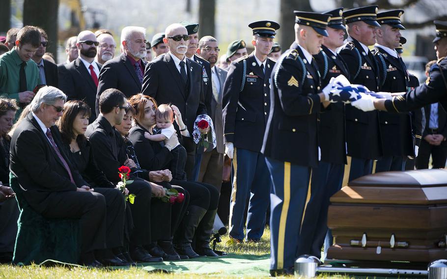 Alexandra D. McClintock, center, kisses her son, Declan, during the graveside service of her husband, U.S. Army Sgt. 1st Class Matthew Q. McClintock, in Section 60 of Arlington National Cemetery, on March 7, 2016. McClintock was killed in action Jan. 5, 2016, in Afghanistan.