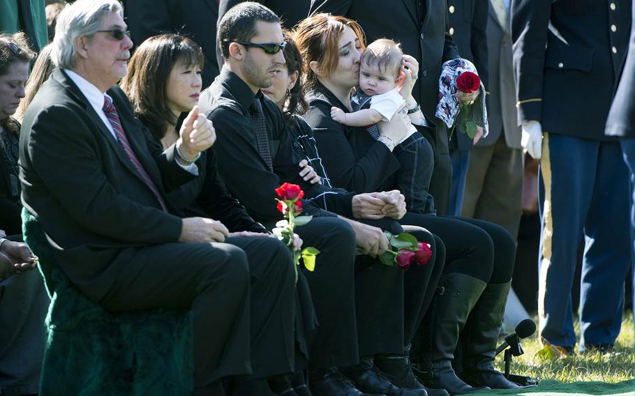 Alexandra D. McClintock, second from right, kisses her son, Declan, during the service for her husband, U.S. Army Sgt. 1st Class Matthew Q. McClintock, in Section 60 of Arlington National Cemetery, on March 7, 2016. McClintock was killed in action Jan. 5 in Afghanistan. 