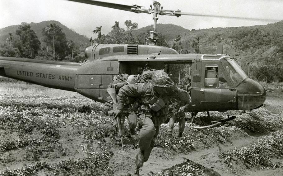 101st Airborne Division soldiers move away from the landing zone after being dropped off by a 176th Aviation Company Huey helicopter during Operation Wheeler in 1967.  
