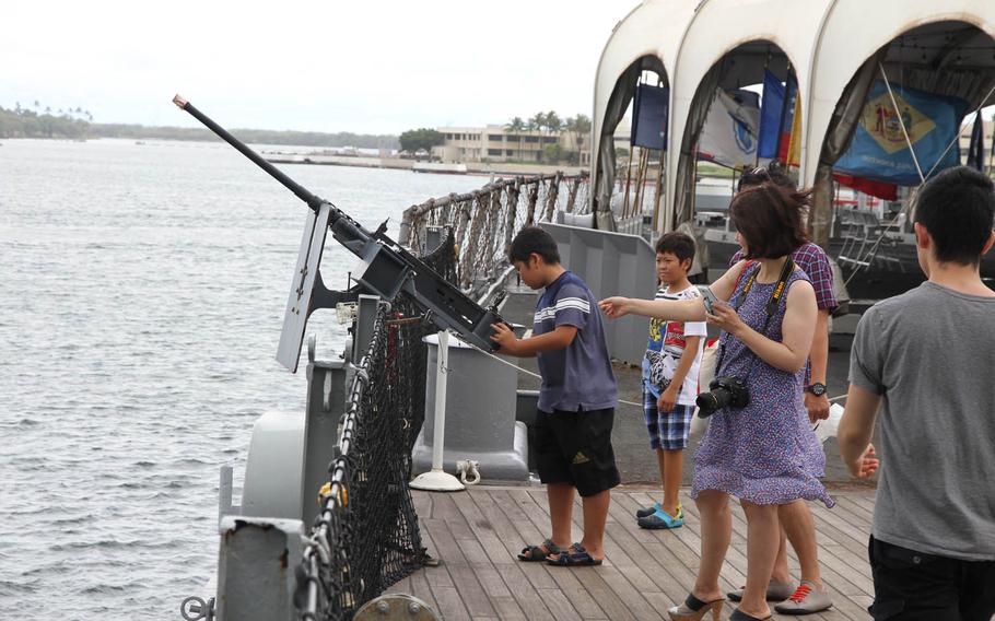 Visitors at the Missouri Battleship Memorial in Pearl Harbor, Hawaii, get a hands-on look at one of the anti-aircraft guns on the ship.