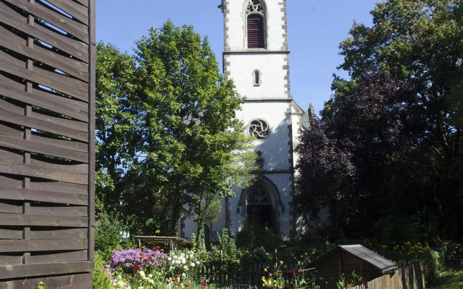 The Catholic St. Lawrence church in Eppstein, Germany, rises next to a flower garden. Eppstein's well-preserved old town features a number of restaurants, shops and wineries, just minutes from Wiesbaden.