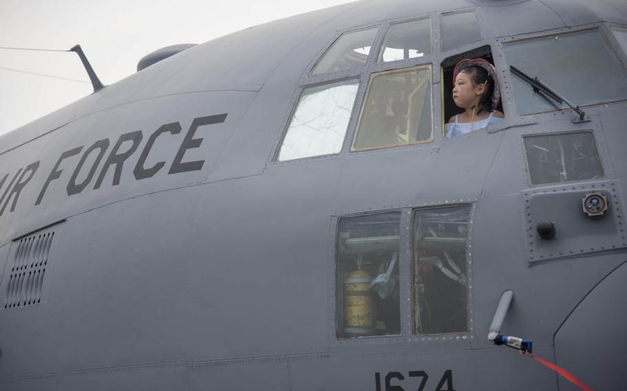 A child pokes her head out of the window of a C-130 Hercules at the 2016 Friendship Festival at Yokota Air Base, Japan, Saturday, Sept. 17, 2016.