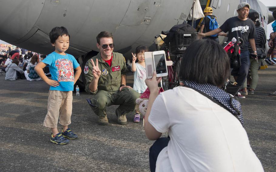 1st Lt. Lionel Alford, a 36th Airlift Squadron C-130 Hercules pilot, poses with Friendship Festival attendees at Yokota Air Base, Japan, Saturday, Sept. 17, 2016. The event included live music, a strongman competition, aerial and static displays and a military working dog demonstration.