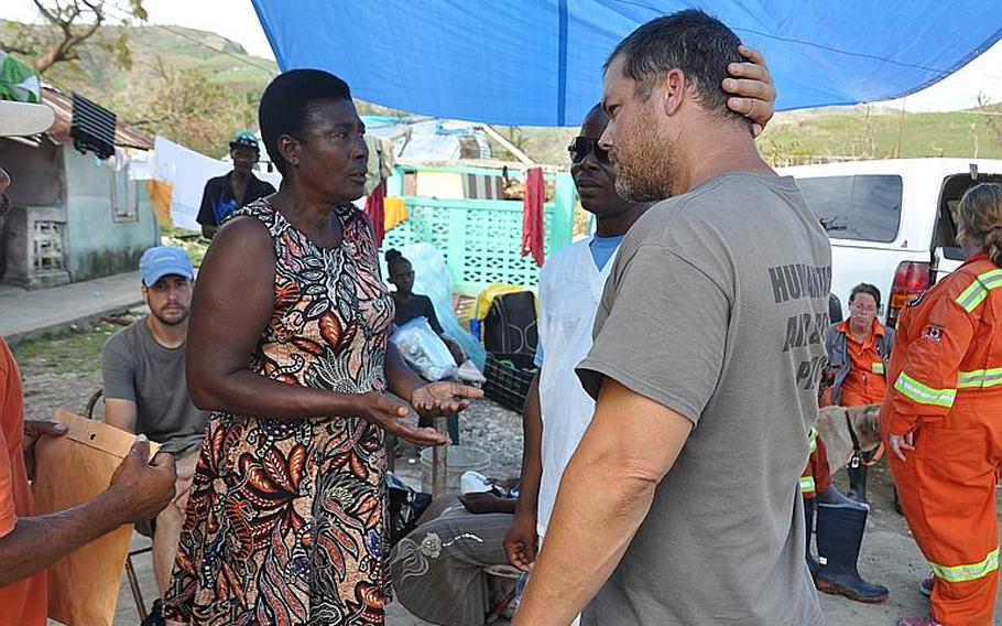 Yvette Moise, left, a resident of Lansing Michigan and native of the southwest Haiti village of Jabouin, talks with Navy veteran Burke Bryant, right, co-founder of Humanitarian Aid and Rescue Project on Oct. 18. Burke's group is helping Moise, who has a house and land in the village, organize food and medical help for members of the village after it took a direct hit from Hurricane Matthew.