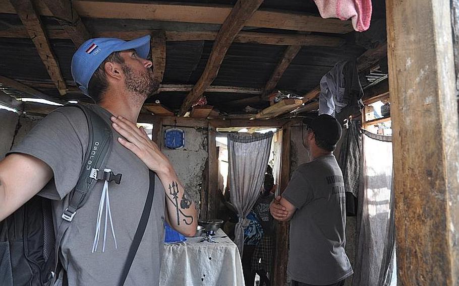 William Gagan, left, and Burke Bryant, right, of the Humanitarian Aid and Rescue Project, inspect a damaged home in the southwest Haiti village of Jabouin on Oct. 18. 