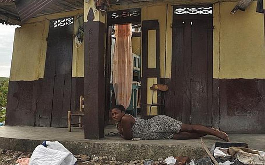 Joseph Rose Yvette, lies bereft on the porch of her roofless home Oct. 18, after Hurricane Matthew took not only the shelter for the five-member family, but also the crops she sells at market to make a living. 