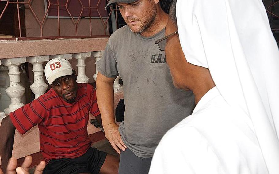 Jackson Bogait, left, a resident of the southwest Haiti village of Jabouin, listens as humanitarian volunteer and Navy veteran Burke Bryant, center, tries to negotiate care for him with a nun at a hospital in the nearby town of Chantal on Oct. 18. The region was ravaged by Hurricane Matthew two weeks ago.