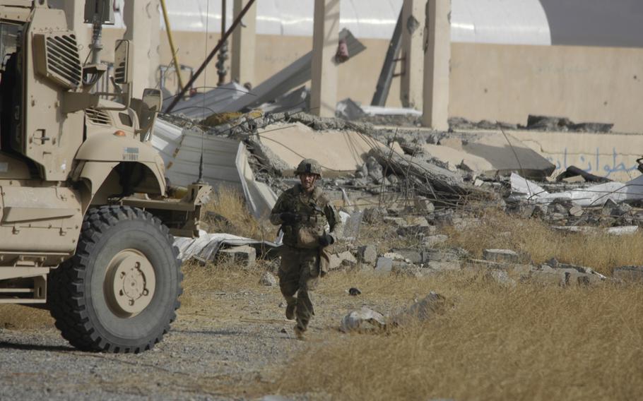 A U.S. soldier working east of Mosul, Iraq, runs after an explosion in a nearby village on Tuesday Nov. 1, 2016.