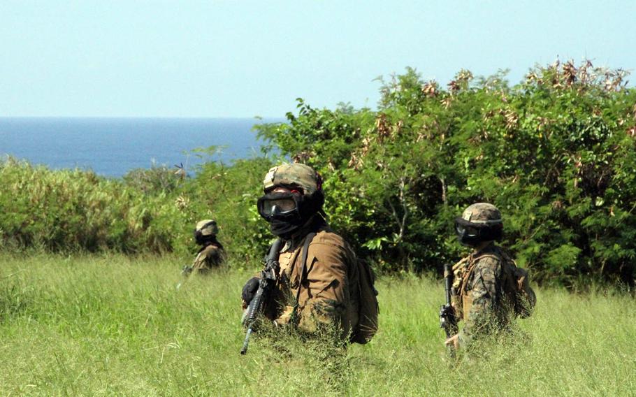 Marines from India Company, 3rd Battalion, 3rd Marine Regiment creep through tall grass on their way to seize Ie Island's airfield from an enemy force, during a drill on Oct. 31, 2016. They wear masks to protect their faces from simulation rounds. The drill was part of Exercise Blue Chromite 2017, a Navy-Marine Corps interoperability exercise that takes place annually on and around Okinawa, Japan.