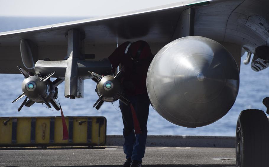 A sailor checks ordnance on the wing of a Rafale M  fighter-bomber prior to flight operations onboard the French aircraft carrier Charles de Gaulle in the eastern Mediterranean on Nov. 25, 2016.  The carrier is operating in support of the coalition fighting the Islamic State group in Iraq and Syria.