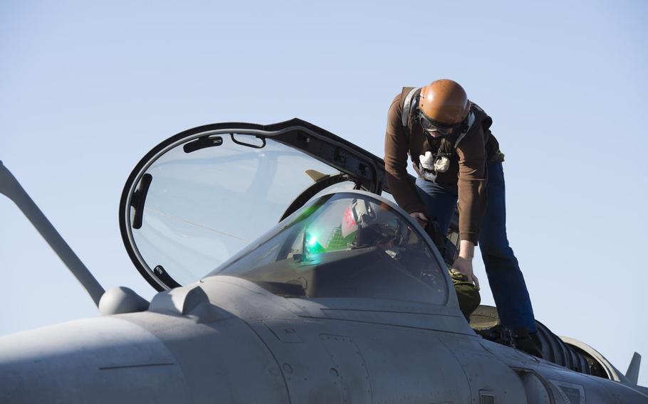 A crew member assists a pilot of a Rafale M fighter-bomber prior to launching from the French aircraft carrier Charles de Gaulle in the eastern Mediterranean on Nov. 25, 2016. The carrier is participating  in airstrikes against the Islamic State group in Iraq and Syria.