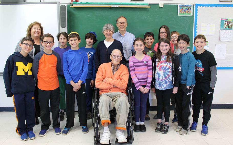 Fifth-graders and their teacher, Carol Gannon, second from left, pose with Mr. Anderson and his family for a group photo.