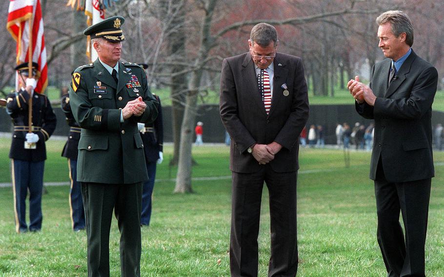 Maj. Gen. Michael Ackerman, left, applauds Hugh Thompson Jr., center, and Lawrence Colburn at the Vietnam Veterans Memorial in Washington Friday, March 6, 1998, during a ceremony where they received the Soldier's Medal. Thirty Years after aiming their weapons at fellow Americans to rescue Vietnamese civilians from the My Lai massacre, the two, along with the late Glenn Andreotta, were finally proclaimed heroes by the Army.